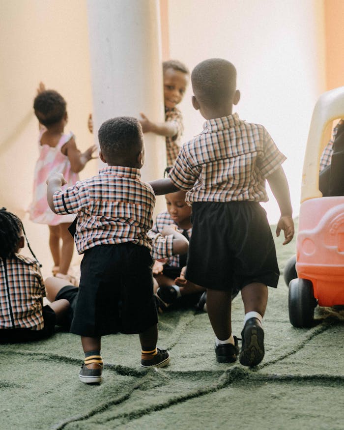 services-01 A group of young children enjoying playtime at school, dressed in uniforms.