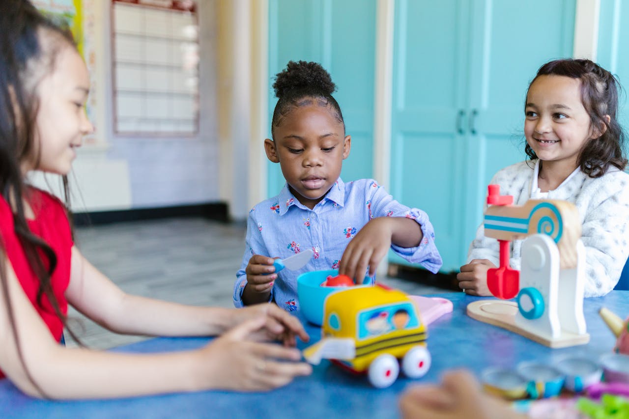 Young children playing and learning with toys in a bright classroom setting.