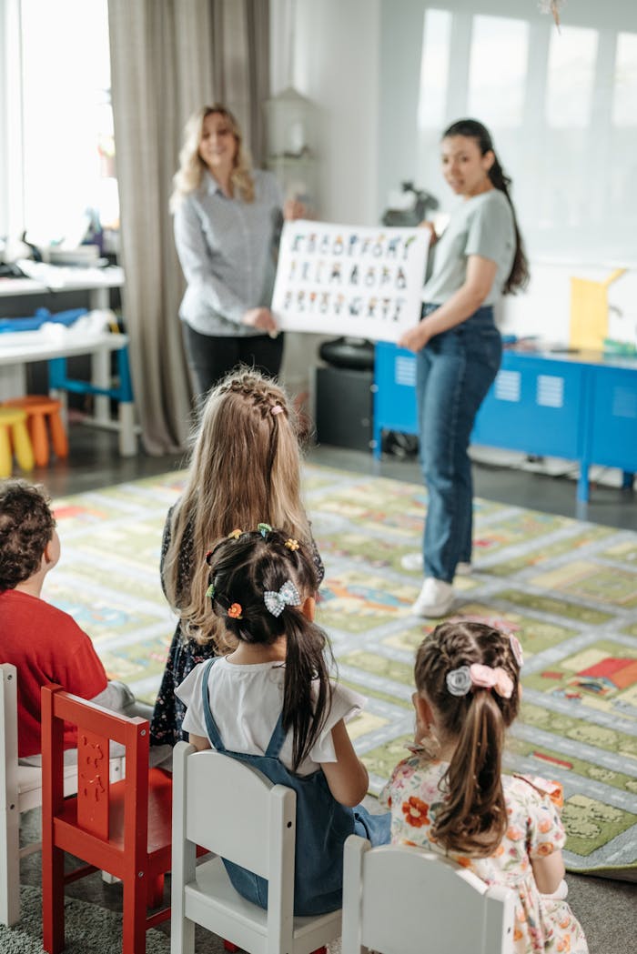 services-02 Young children engaged in a fun alphabet lesson with teachers in a kindergarten classroom.