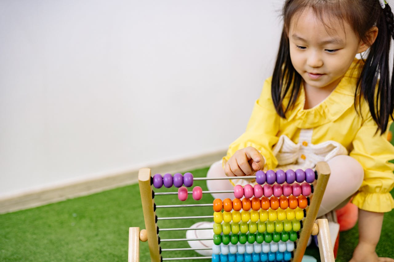services-img A young girl enjoying an educational moment with a vibrant abacus, teaching counting and fun.